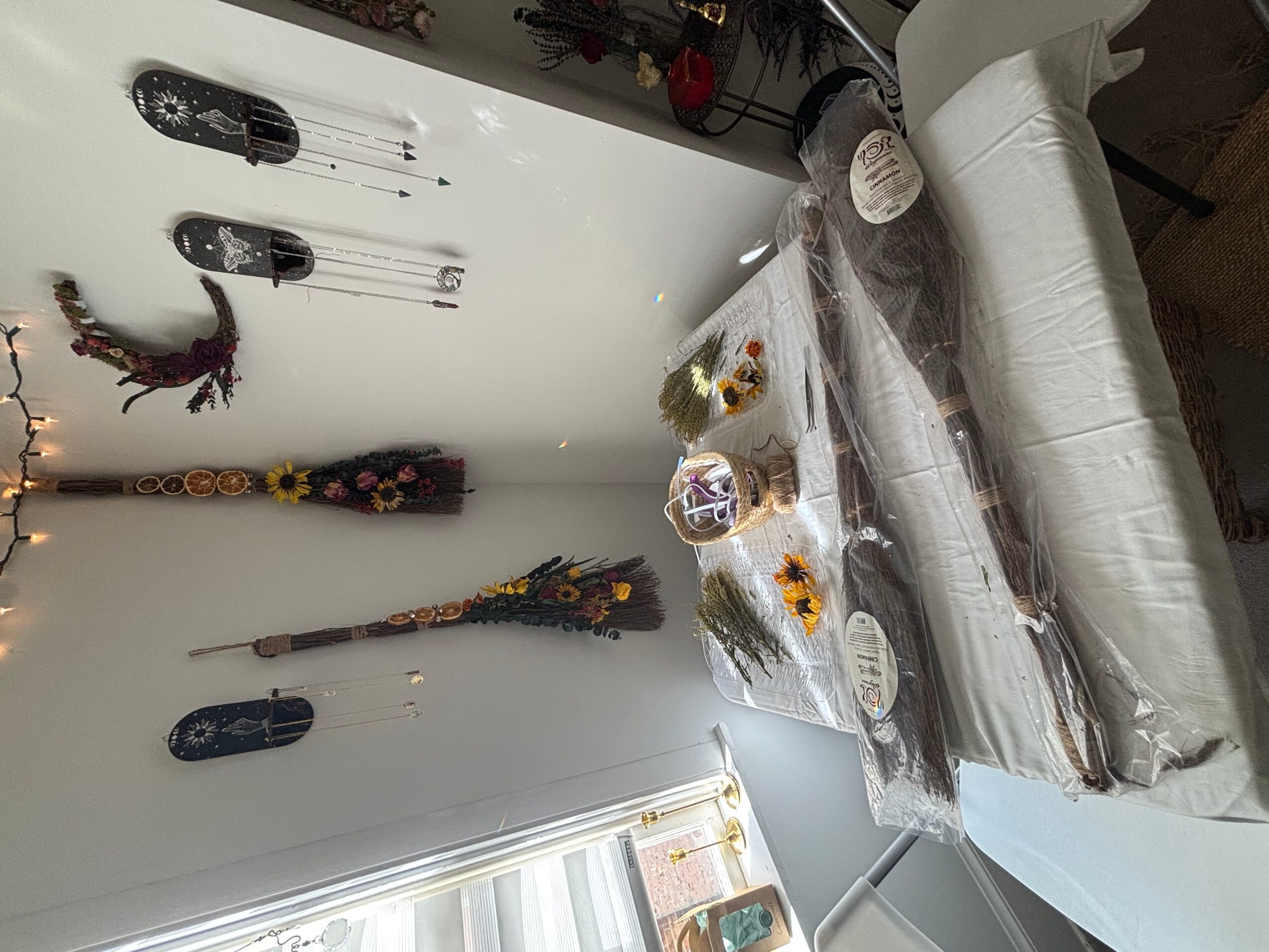 Table with food and decorations, wall with hanging ornaments, and a window with natural light.