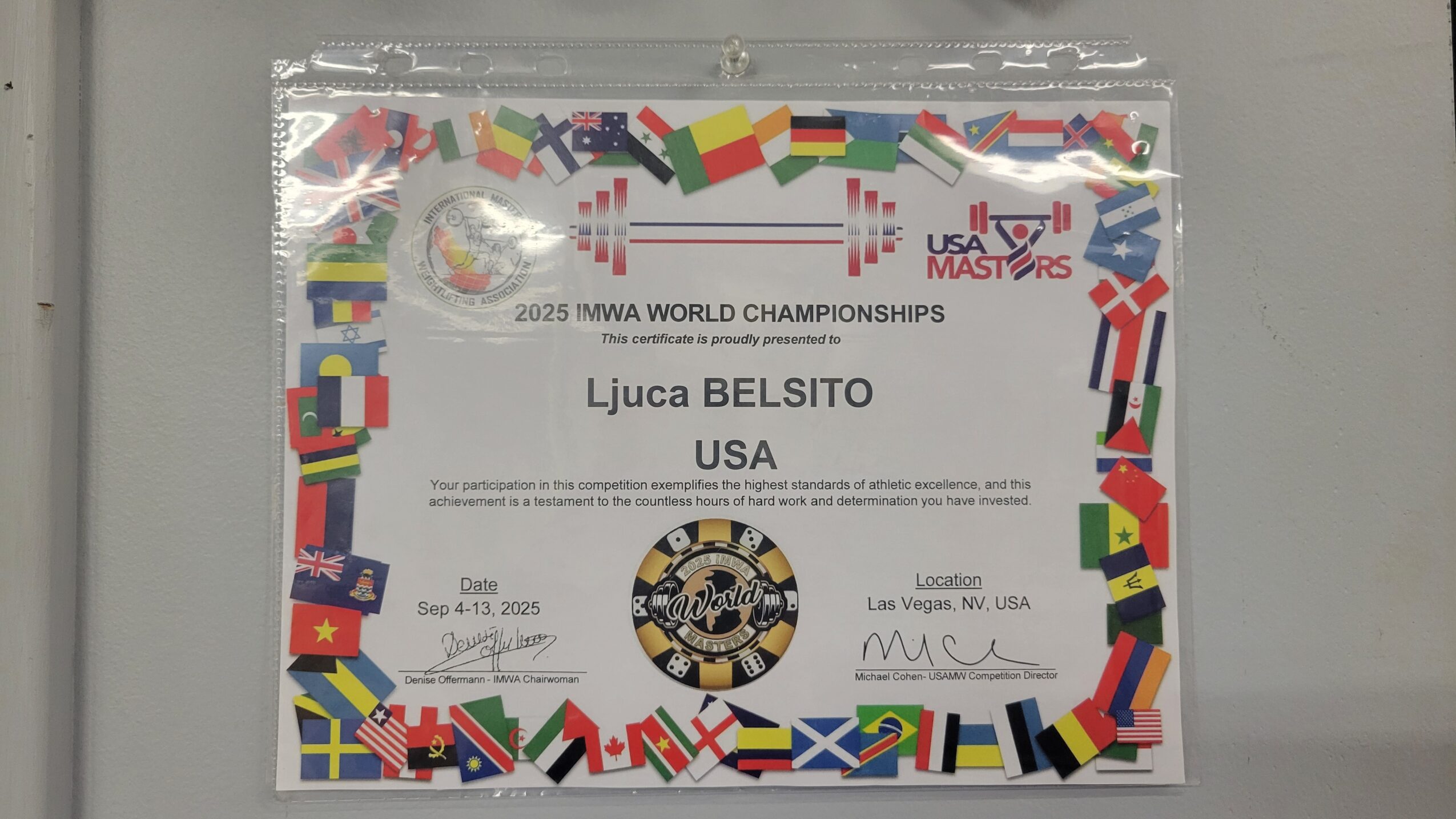 Certificate with flags border, titled '2023 IWMA WORLD CHAMPIONSHIPS,' awarded to Ljuca Belsito from USA, with signatures and a logo.