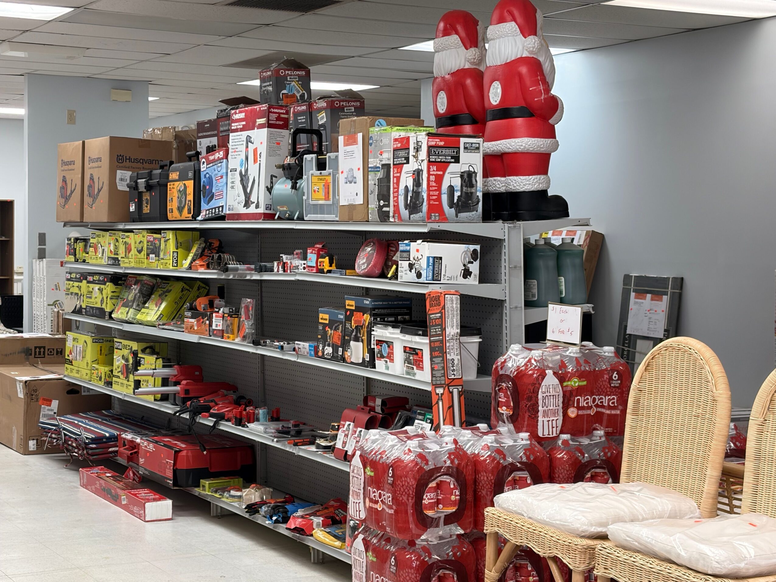 Store aisle with shelves stocked with red and yellow boxed products, and some baskets on the left side.
