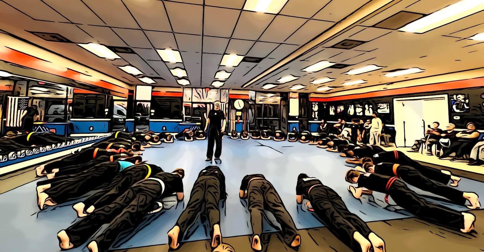 People lying face down on the floor in a room with bright ceiling lights and seating areas, with a person standing in the center.