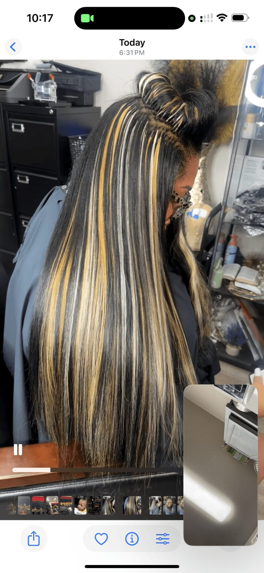 Side view of a woman with long, straight hair featuring blonde, black, and gray highlights, in a salon setting.