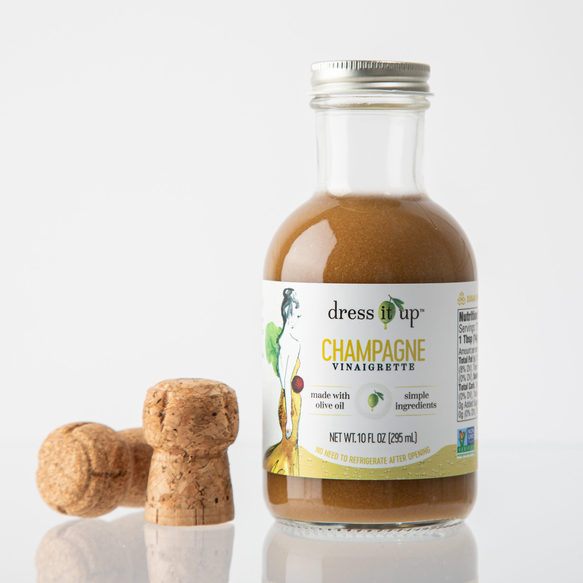 Small bottle of champagne vinaigrette with three croutons beside it, on a white background.