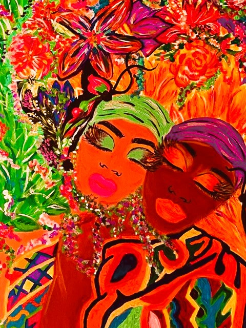 Two women with colorful makeup and hair, surrounded by vibrant flowers and foliage, smiling and embracing each other.