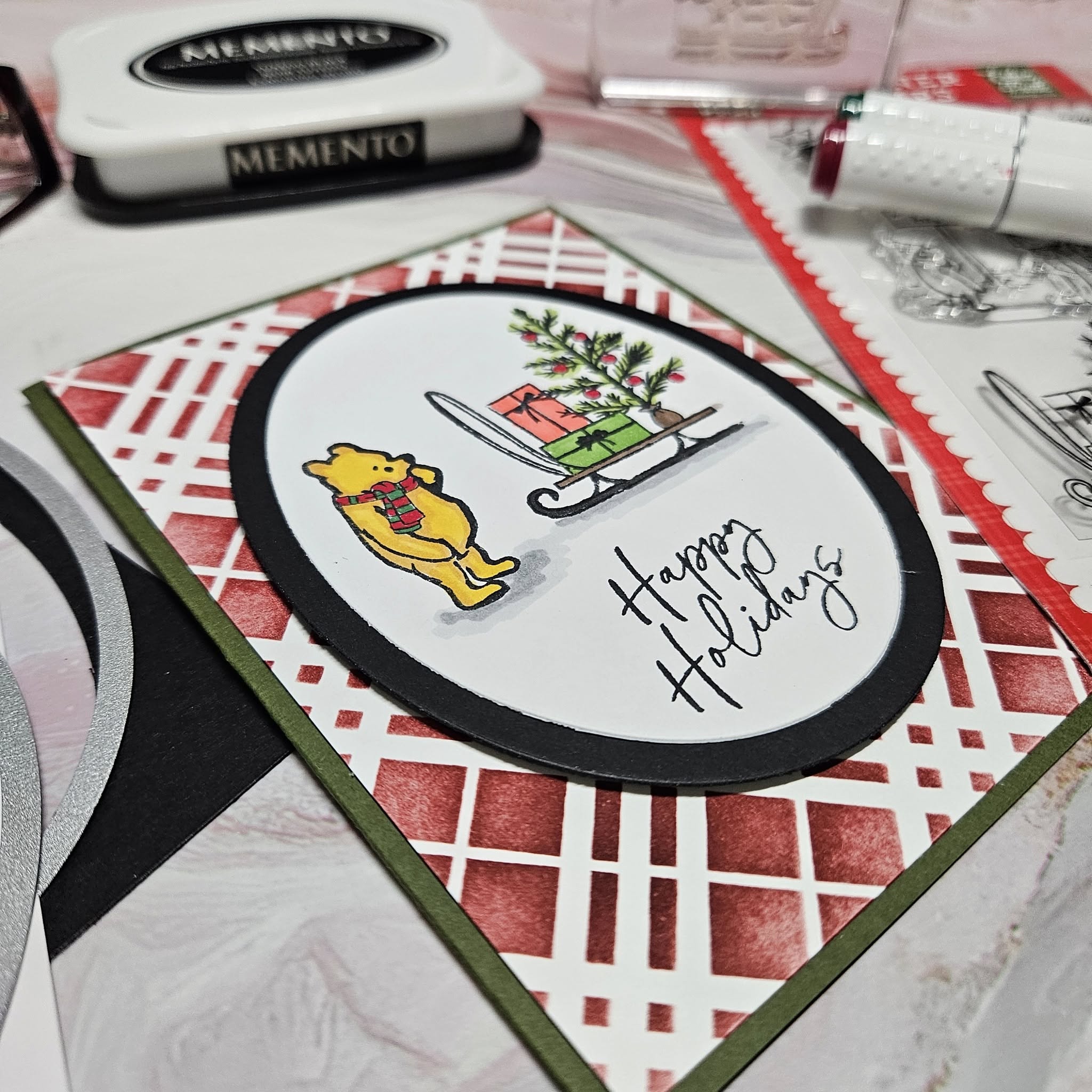 Holiday card with a yellow dog, Christmas tree, and sled, with 'Happy Holidays' written on it, on a red and white patterned background.