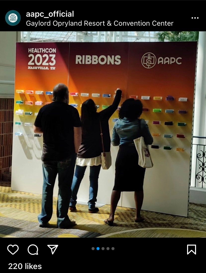 Three people stand in front of a display with ribbons at Gaylord Opryland Resort, with a red background and text about health conference.