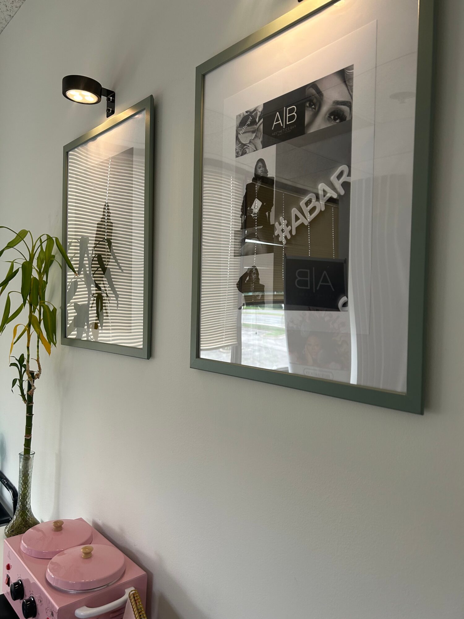 Two framed posters on a white wall, one with black and white images and text, the other with a drawing of a person.