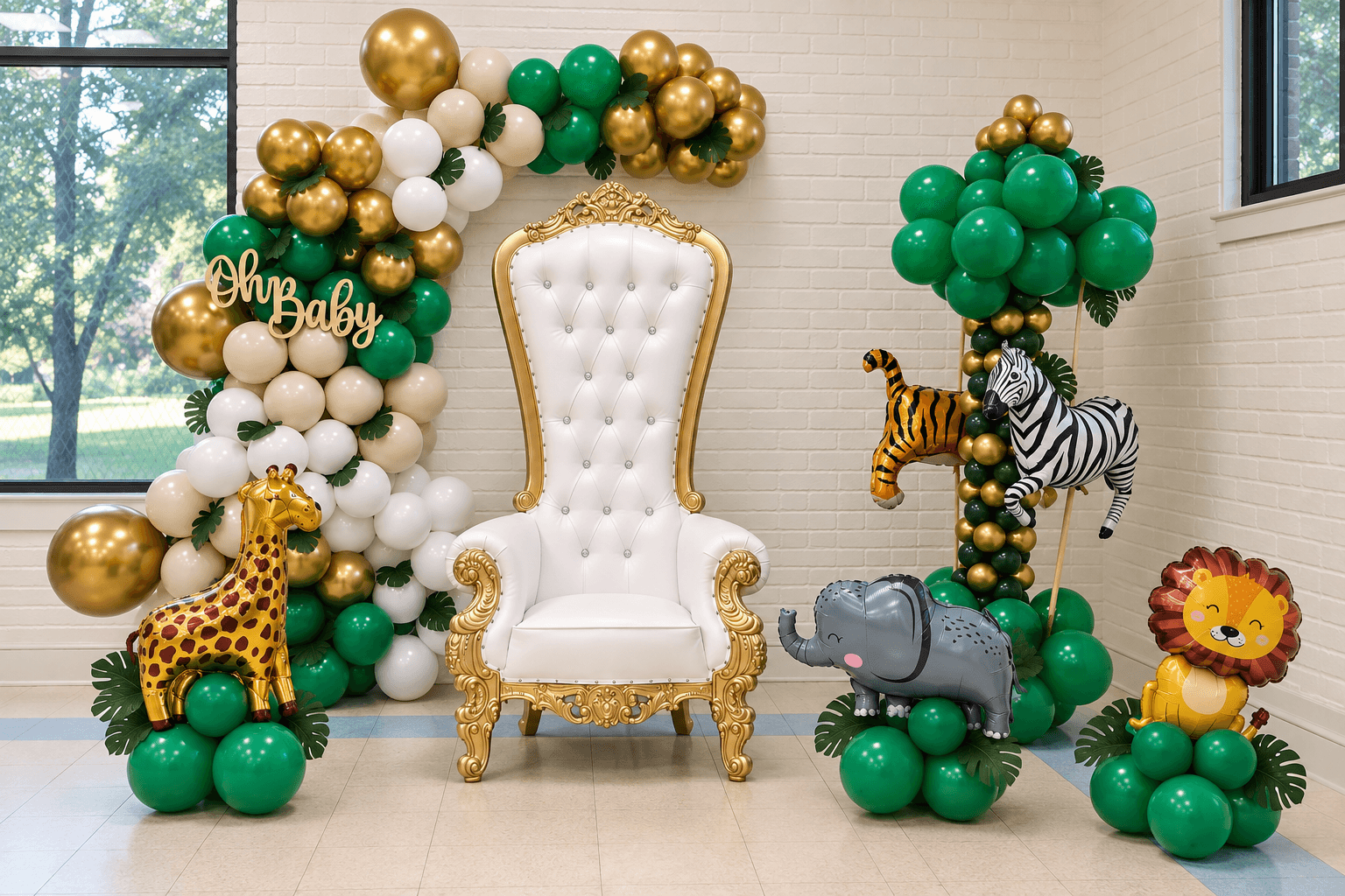 Decorations with balloons, a white ornate chair, and animal figures including a giraffe, zebra, hippopotamus, and lion in a room.