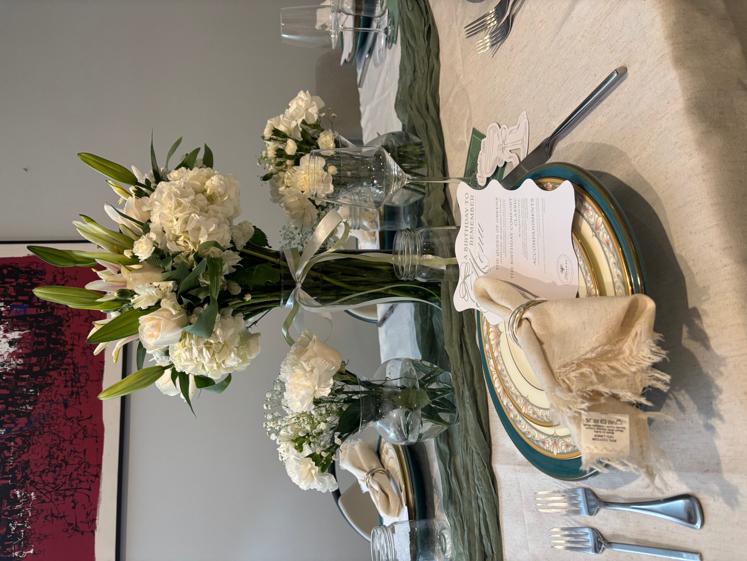 Table setting with floral centerpiece, plates, napkin, and cutlery on a tablecloth.