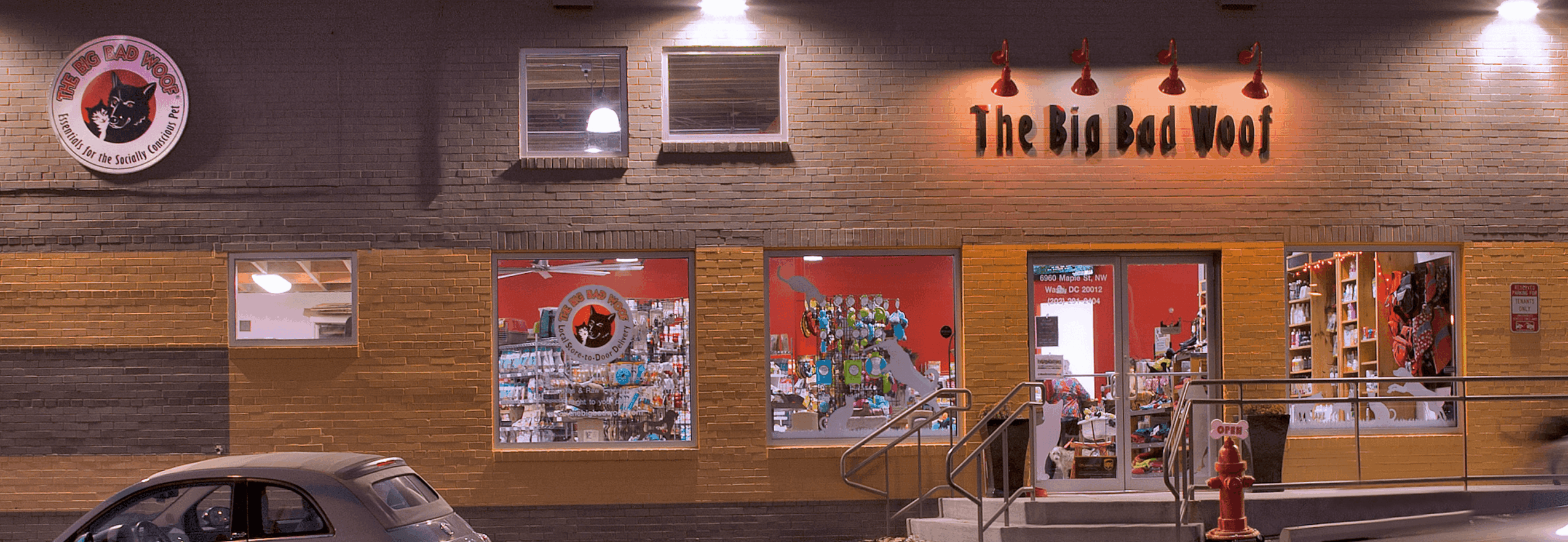 Storefront with wooden panels, colorful artwork, and a sign reading 'The Big Bad Wolf'.