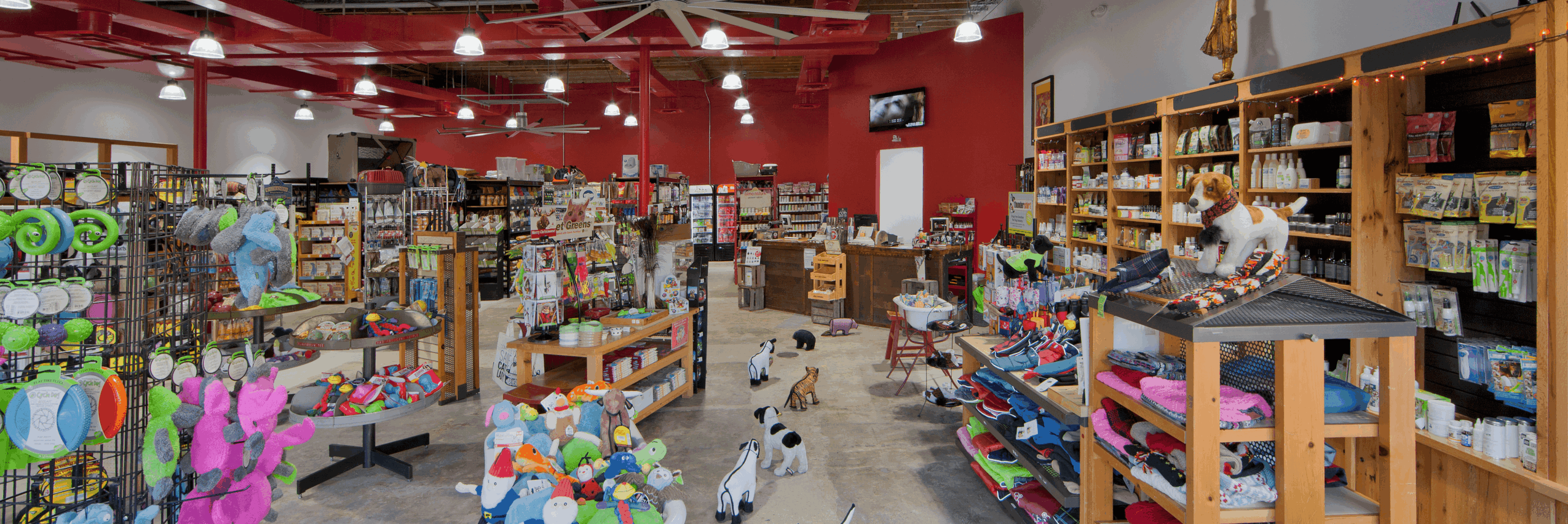 Store interior with shelves and displays of toys, games, and craft supplies, red ceiling, and bright lighting.